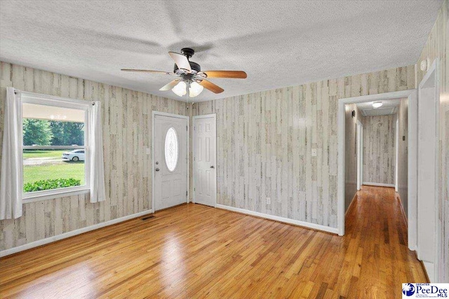 317 Thomas St, Bennettsville, SC 29512 - foyer featuring wood finished floors, a ceiling fan, a textured ceiling, and wallpapered walls