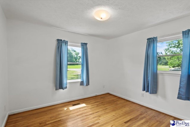 317 Thomas St, Bennettsville, SC 29512 - unfurnished room with light wood-style floors and a textured ceiling