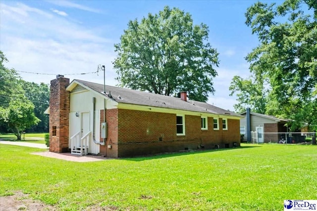 317 Thomas St, Bennettsville, SC 29512 - rear view of property featuring a chimney, a yard, entry steps, and brick siding