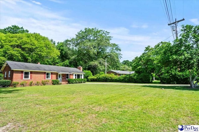 317 Thomas St, Bennettsville, SC 29512 - view of front of house with a front lawn, a chimney, and brick siding