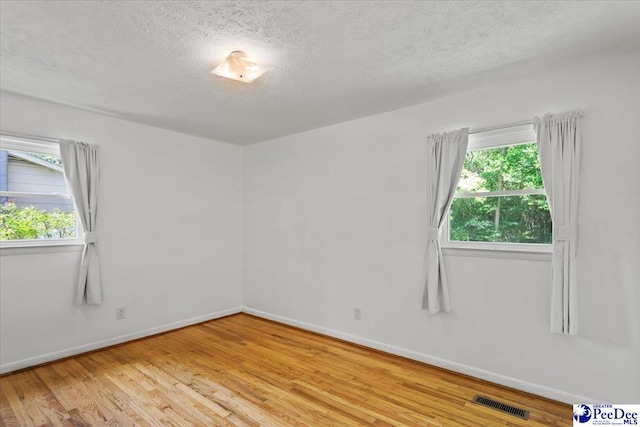 317 Thomas St, Bennettsville, SC 29512 - spare room featuring a textured ceiling, wood finished floors, and healthy amount of natural light