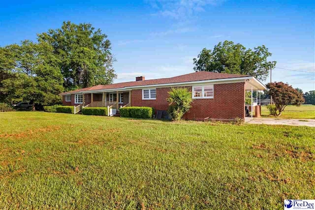 ranch-style house with a front lawn, concrete driveway, brick siding, and a chimney