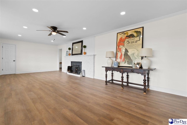 living room with wood finished floors, baseboards, recessed lighting, ceiling fan, and ornamental molding