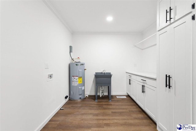 laundry room with washer hookup, crown molding, dark wood-style flooring, and electric water heater