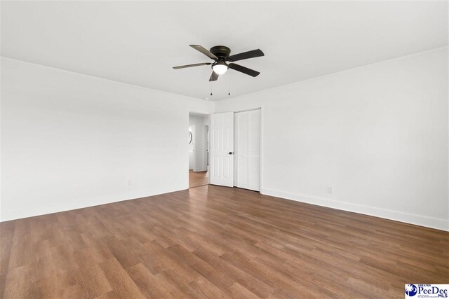 empty room with baseboards, a ceiling fan, and wood finished floors