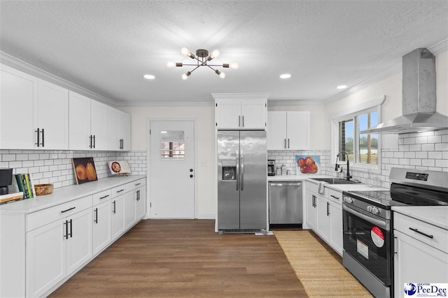 kitchen with ornamental molding, wall chimney exhaust hood, appliances with stainless steel finishes, and a sink