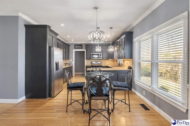 dining space with an inviting chandelier, baseboards, and ornamental molding