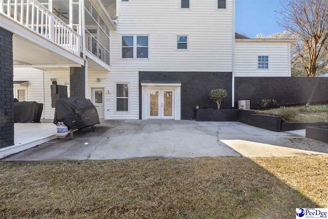 back of house featuring a patio area, french doors, and brick siding