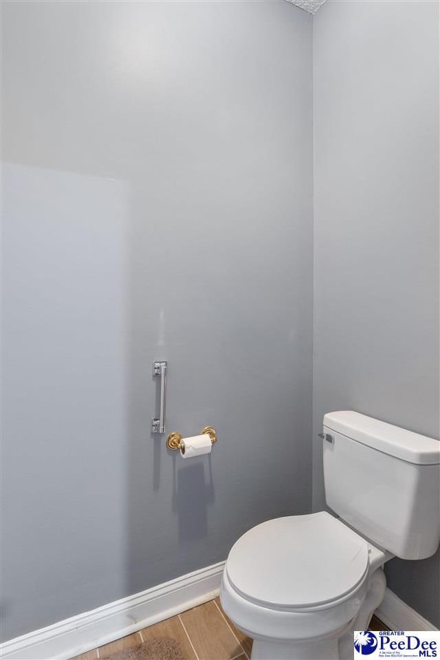 bathroom with baseboards and toilet