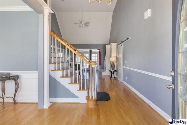 foyer featuring wood finished floors, decorative columns, baseboards, ceiling fan, and stairs