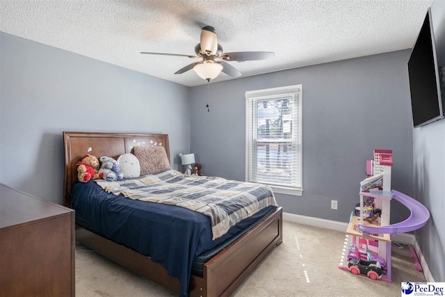 bedroom featuring baseboards, light carpet, a textured ceiling, and a ceiling fan