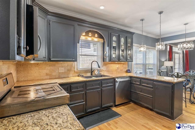 kitchen featuring crown molding, light wood-type flooring, appliances with stainless steel finishes, a peninsula, and a sink