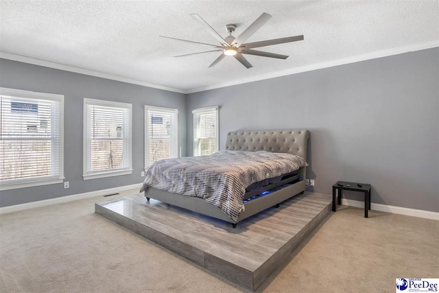 carpeted bedroom featuring crown molding, multiple windows, baseboards, and a textured ceiling