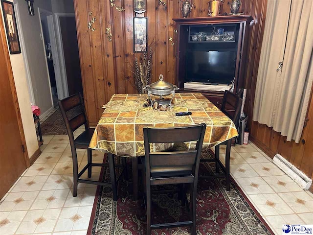 dining area featuring wooden walls and light tile patterned flooring