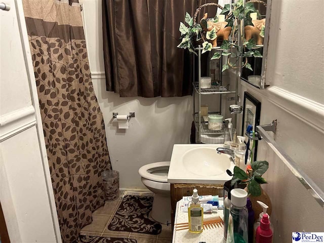 full bathroom featuring a shower with curtain, tile patterned floors, toilet, and a sink