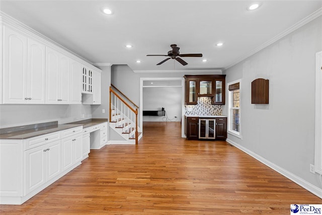 kitchen with recessed lighting, baseboards, light wood-style floors, white cabinets, and dark countertops