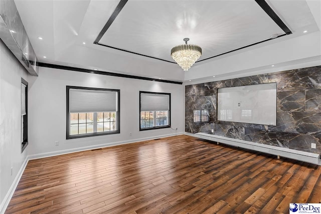 unfurnished living room with recessed lighting, a tray ceiling, a notable chandelier, and wood finished floors