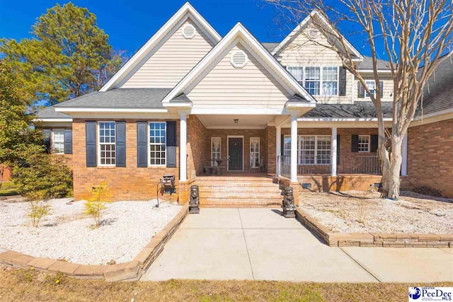 view of front facade with covered porch and brick siding