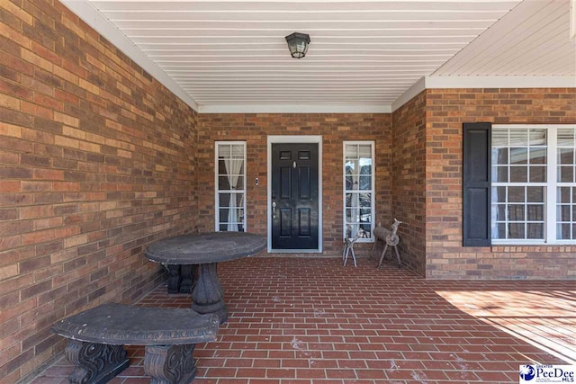 view of exterior entry featuring brick siding