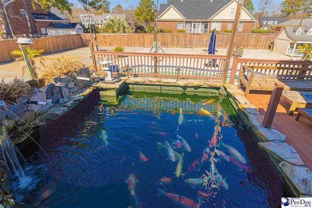 view of pool featuring a fenced backyard, a fenced in pool, and a deck with water view