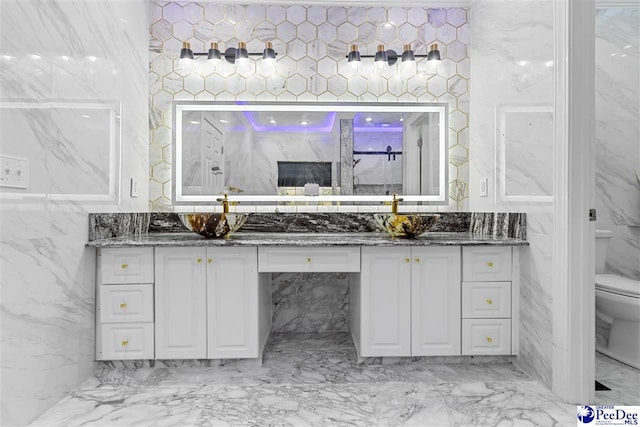 full bathroom with tile walls, marble finish floor, vanity, and toilet