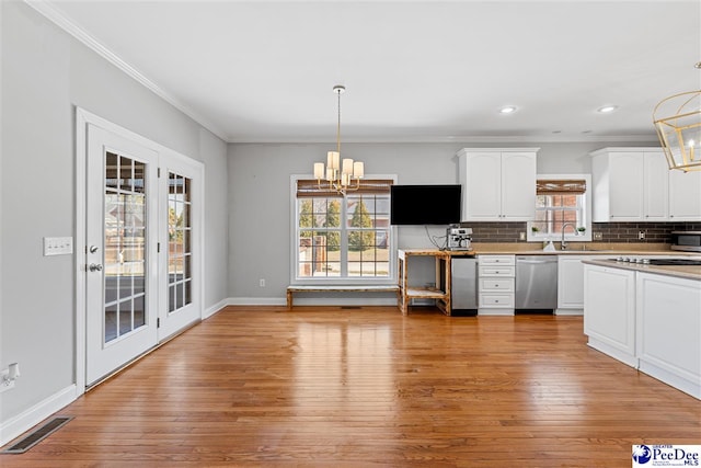 kitchen featuring stainless steel appliances, pendant lighting, white cabinetry, and visible vents