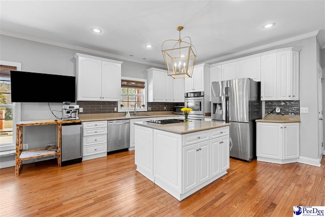 kitchen featuring hanging light fixtures, white cabinetry, a kitchen island, and appliances with stainless steel finishes