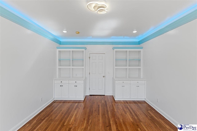 unfurnished bedroom with baseboards and dark wood-type flooring