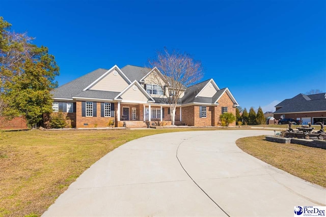 view of front of property featuring crawl space, a front yard, concrete driveway, and brick siding