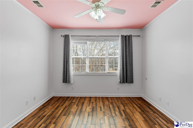 spare room with dark wood finished floors, visible vents, and baseboards