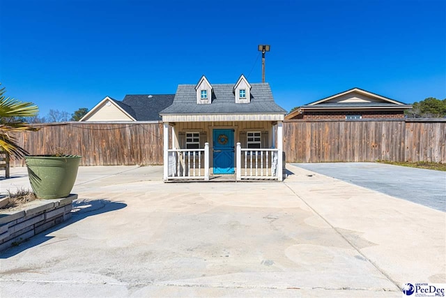 view of front of property featuring covered porch and fence