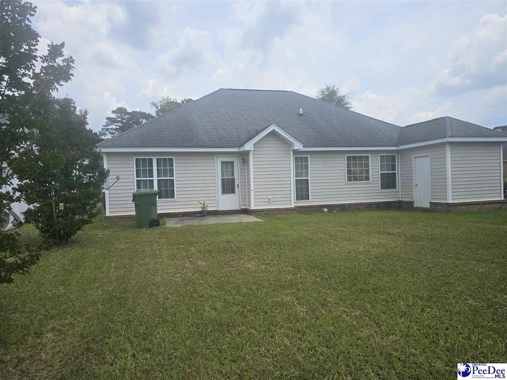1621 Southwood Ct, Florence, SC 29505 - back of property with a yard, a patio area, and roof with shingles