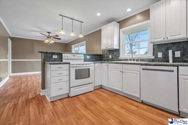 kitchen with white electric range oven, sink, dishwasher, white cabinets, and crown molding