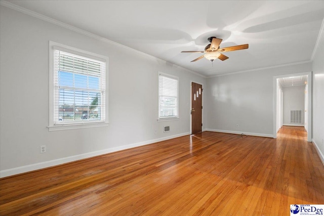 unfurnished room featuring ceiling fan, ornamental molding, hardwood / wood-style floors, and plenty of natural light