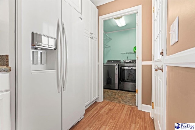 corridor with washing machine and dryer and light wood-type flooring