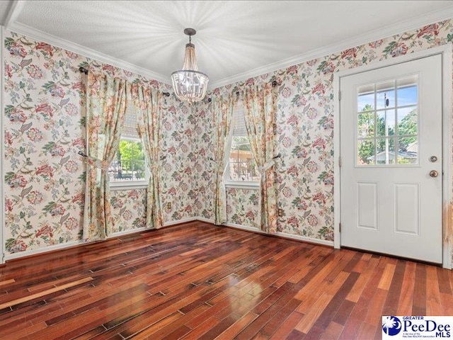 unfurnished dining area with an inviting chandelier, wood finished floors, a healthy amount of sunlight, and crown molding