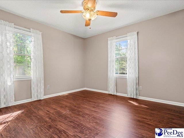 spare room featuring ceiling fan, wood finished floors, and baseboards