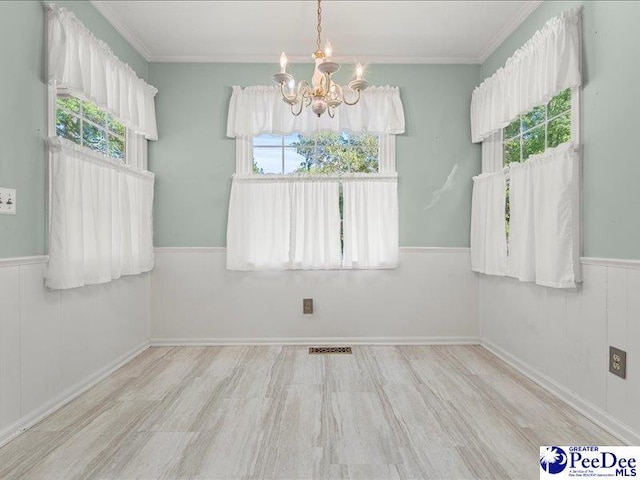 unfurnished dining area with ornamental molding, visible vents, wood finished floors, and a chandelier