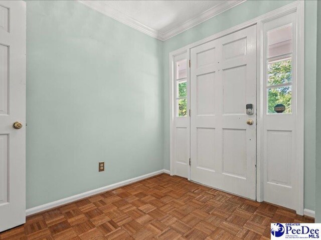 foyer with ornamental molding, a wealth of natural light, and baseboards