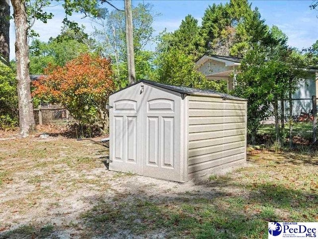 view of shed featuring fence