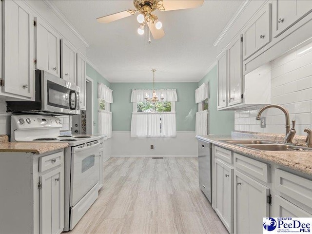 kitchen featuring tasteful backsplash, a sink, appliances with stainless steel finishes, light countertops, and ceiling fan with notable chandelier