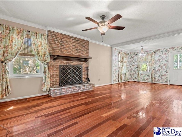 unfurnished living room featuring ceiling fan, crown molding, visible vents, baseboards, and wood finished floors