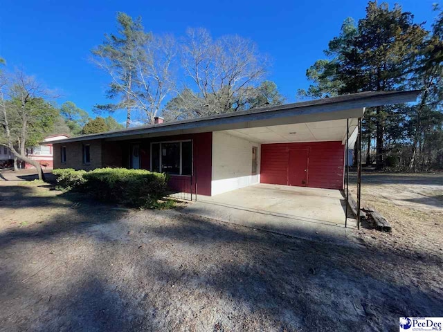 ranch-style home with a carport and driveway