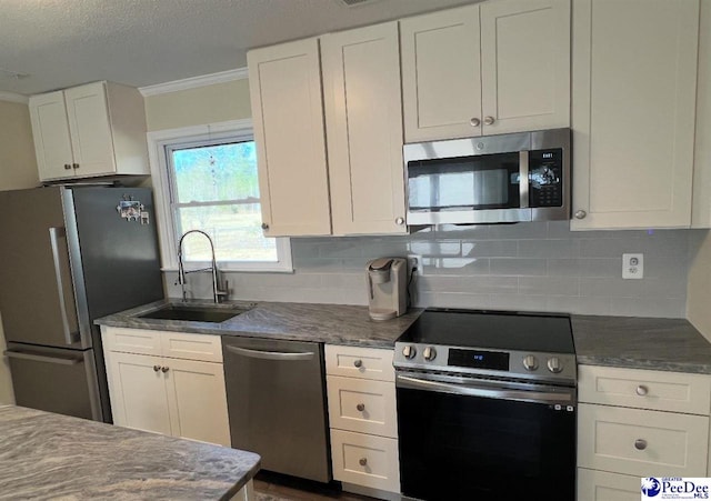 kitchen featuring sink, crown molding, stainless steel appliances, white cabinets, and decorative backsplash