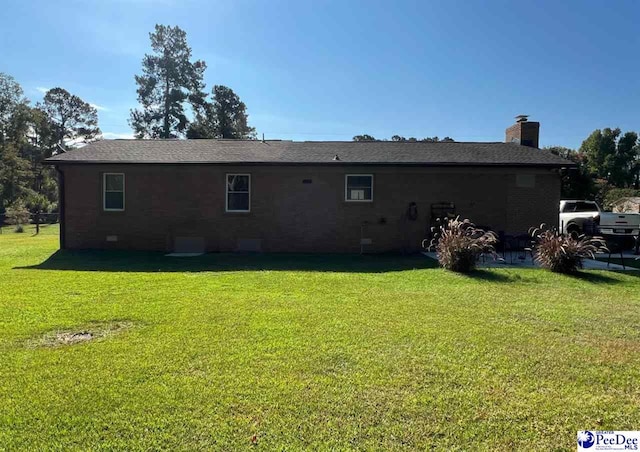 rear view of house featuring a yard