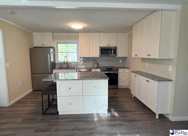 kitchen with sink, a center island, white cabinets, and appliances with stainless steel finishes