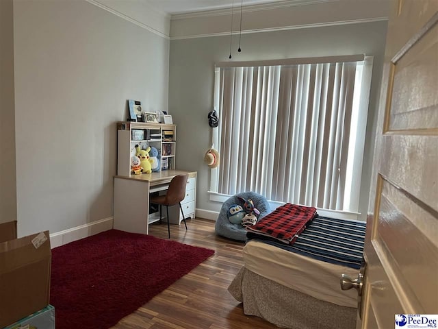 interior space with baseboards, wood finished floors, and crown molding