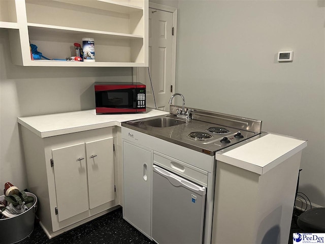 kitchen with light countertops, open shelves, and a sink