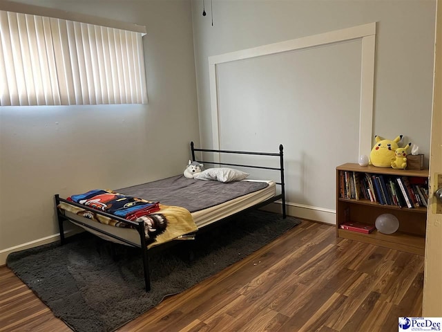 bedroom with baseboards and wood finished floors