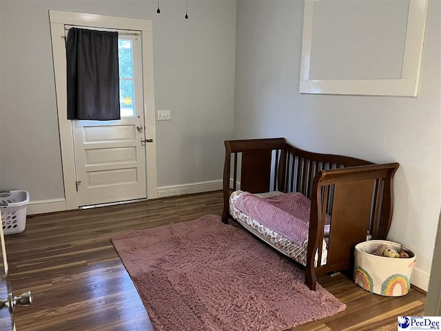 bedroom featuring baseboards and wood finished floors